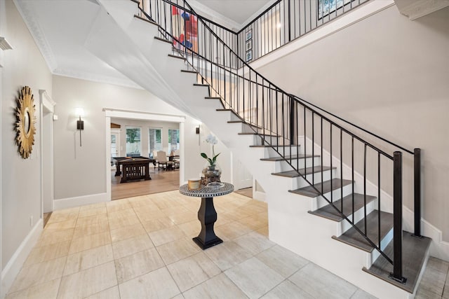8703 Chelmsford Ln, Spring, TX 77379 - stairway featuring crown molding, tile patterned flooring, and a towering ceiling