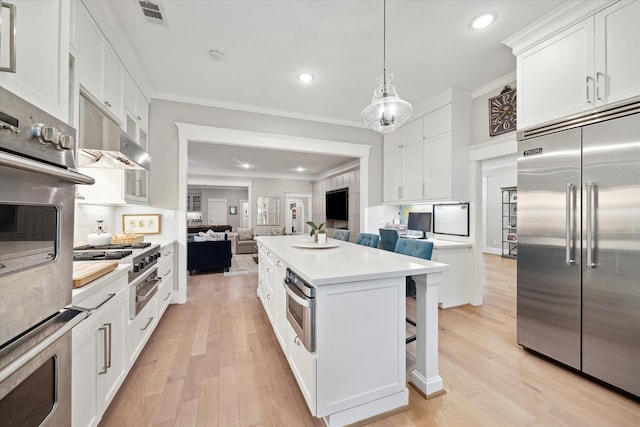 8703 Chelmsford Ln, Spring, TX 77379 - kitchen with appliances with stainless steel finishes, open floor plan, recessed lighting, a center island, and white cabinets
