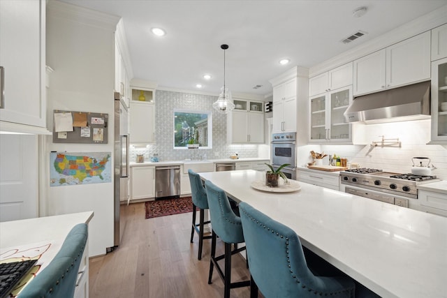 8703 Chelmsford Ln, Spring, TX 77379 - kitchen with appliances with stainless steel finishes, under cabinet range hood, backsplash, white cabinets, and recessed lighting
