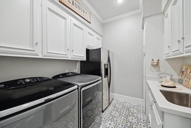 8703 Chelmsford Ln, Spring, TX 77379 - laundry room with crown molding, washing machine and dryer, light tile patterned floors, and cabinet space