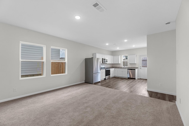 9309 Beryl Ln, Conroe, TX 77303 - kitchen featuring appliances with stainless steel finishes, dark carpet, white cabinetry, recessed lighting, and open floor plan