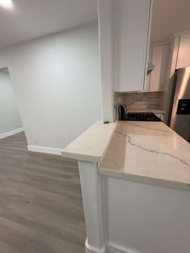 3923 Hickok Ln, Houston, TX 77047 - kitchen with dark wood finished floors, white cabinetry, backsplash, and light stone countertops