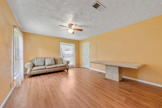 810 W N St, Livingston, TX 77351 - living room with a ceiling fan, light wood finished floors, and a textured ceiling