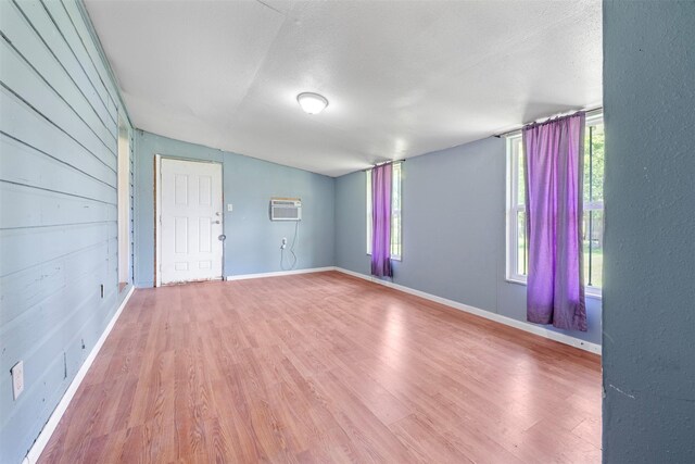 810 W N St, Livingston, TX 77351 - spare room featuring wood finished floors, an AC wall unit, and vaulted ceiling