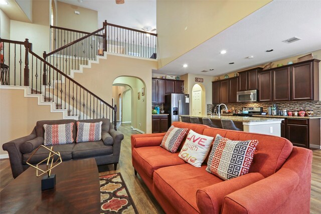 13423 Astley Acres Ln, Cypress, TX 77429 - living area featuring arched walkways, wood finished floors, stairway, recessed lighting, and a high ceiling