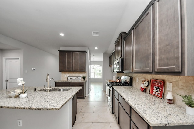 23714 Piedmont Forest Dr, Katy, TX 77493 - kitchen featuring appliances with stainless steel finishes, tasteful backsplash, dark brown cabinetry, recessed lighting, and light stone counters