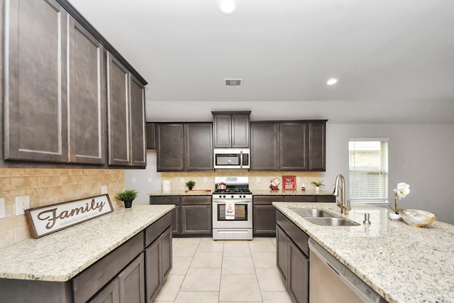 23714 Piedmont Forest Dr, Katy, TX 77493 - kitchen featuring stainless steel appliances, decorative backsplash, dark brown cabinetry, light stone counters, and recessed lighting