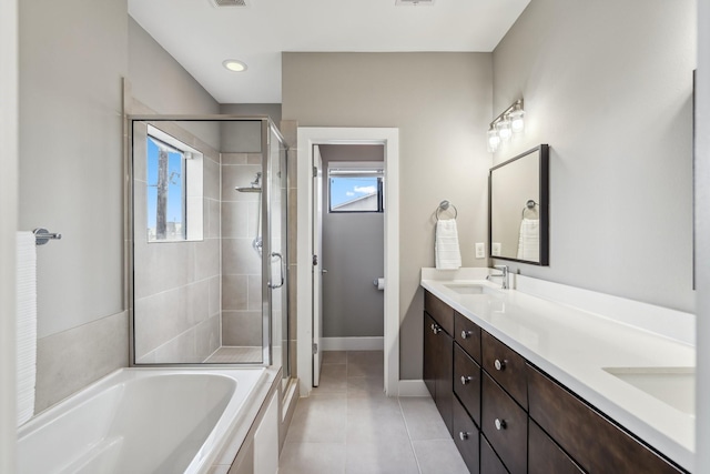703 Bayou St, Houston, TX 77020 - full bath featuring a stall shower, double vanity, a garden tub, and tile patterned flooring