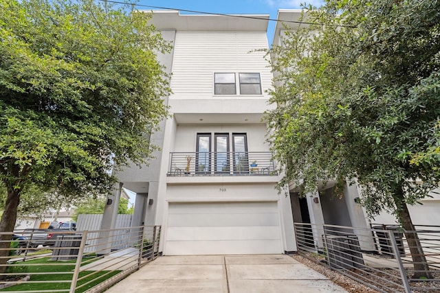 703 Bayou St, Houston, TX 77020 - view of front facade with a balcony, an attached garage, stucco siding, and driveway