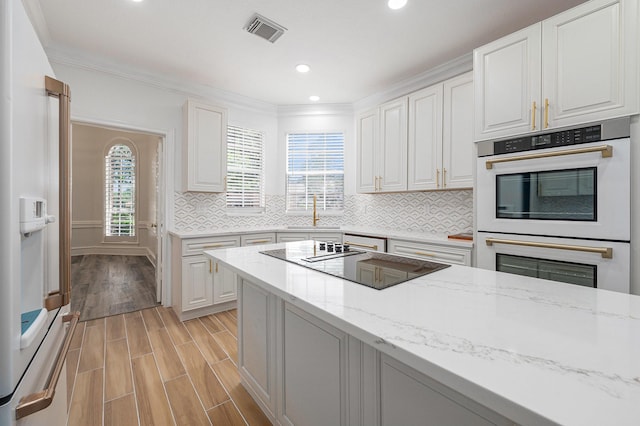 7921 Capri Cir, Houston, TX 77095 - kitchen featuring white appliances, white cabinets, light stone countertops, recessed lighting, and decorative backsplash