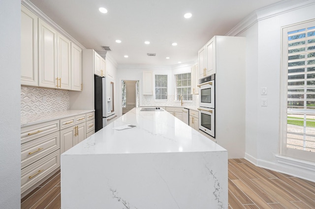 7921 Capri Cir, Houston, TX 77095 - kitchen with white appliances, a kitchen island, recessed lighting, decorative backsplash, and light wood finished floors