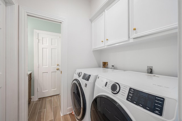 7921 Capri Cir, Houston, TX 77095 - washroom featuring washing machine and clothes dryer, cabinet space, and wood tiled floors