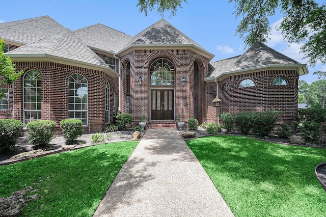 7921 Capri Cir, Houston, TX 77095 - view of front of home with brick siding, french doors, a front lawn, and roof with shingles