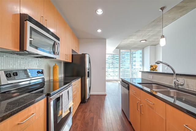 5925 Almeda Rd Unit 11608, Houston, TX 77004 - kitchen with appliances with stainless steel finishes, tasteful backsplash, dark wood-style floors, expansive windows, and dark stone counters