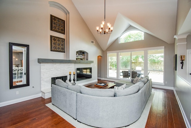 14023 Armant Place Dr, Cypress, TX 77429 - living room with a stone fireplace, dark wood-style flooring, a chandelier, and high vaulted ceiling