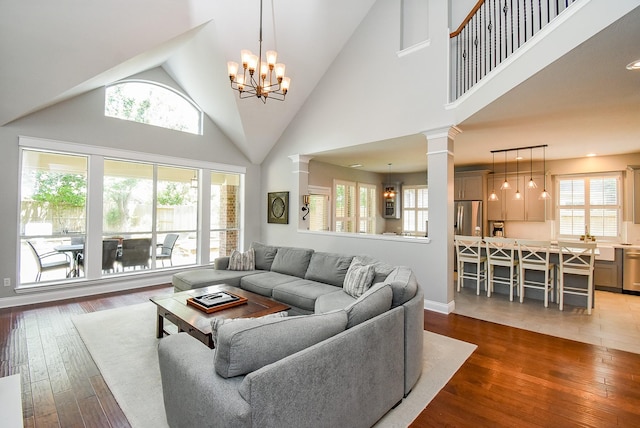 14023 Armant Place Dr, Cypress, TX 77429 - living area featuring plenty of natural light, decorative columns, hardwood / wood-style floors, and high vaulted ceiling