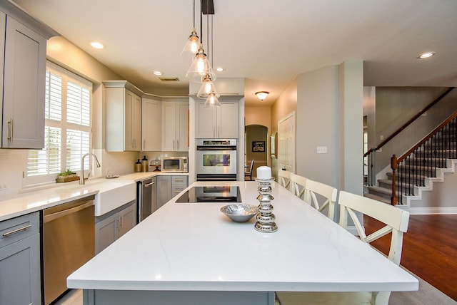 14023 Armant Place Dr, Cypress, TX 77429 - kitchen featuring stainless steel appliances, gray cabinetry, a center island, light countertops, and recessed lighting