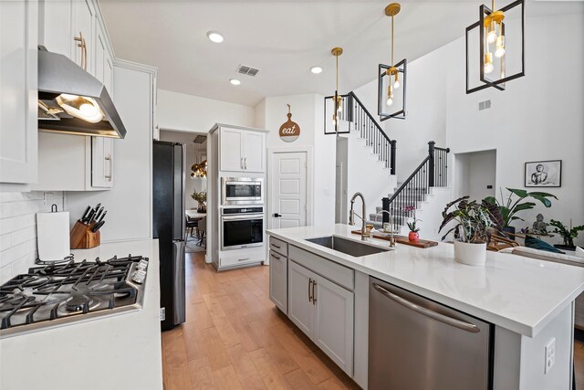 18427 Counce Meadow Ct, Cypress, TX 77433 - kitchen featuring appliances with stainless steel finishes, range hood, light countertops, backsplash, and white cabinetry