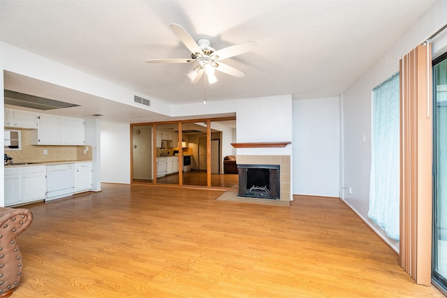 14777 Wunderlich Dr Unit 1103, Houston, TX 77069 - unfurnished living room featuring a ceiling fan, a fireplace, and light wood finished floors