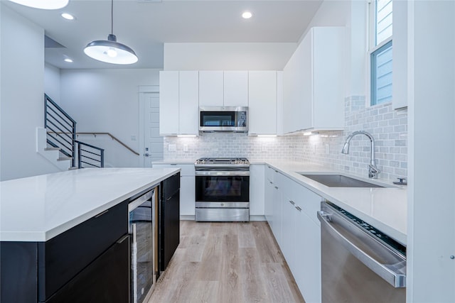 5402 Margarita St, Houston, TX 77020 - kitchen featuring appliances with stainless steel finishes, modern cabinets, light countertops, backsplash, and white cabinets