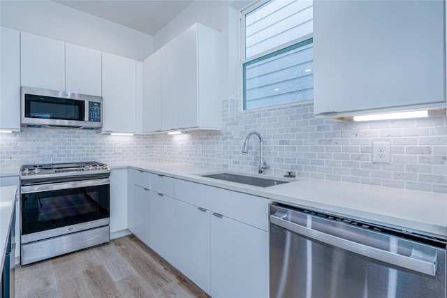 5402 Margarita St, Houston, TX 77020 - kitchen featuring stainless steel appliances, light countertops, light wood-style floors, and decorative backsplash