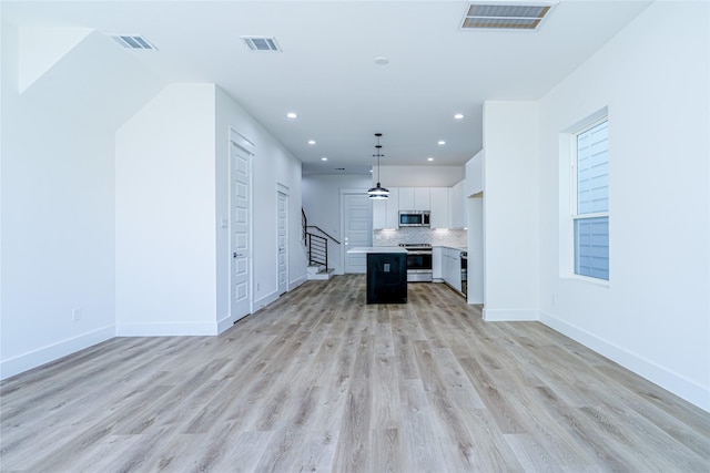 5402 Margarita St, Houston, TX 77020 - kitchen with appliances with stainless steel finishes, open floor plan, white cabinetry, light countertops, and light wood finished floors