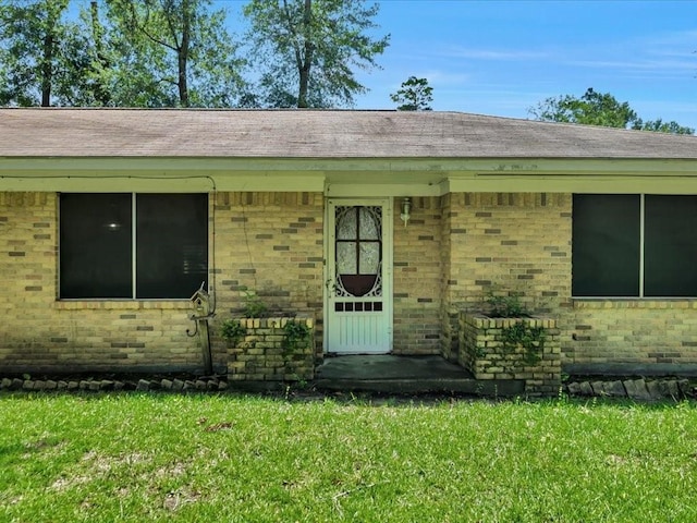 602 Devereaux St, Diboll, TX 75941 - doorway to property featuring brick siding and a yard