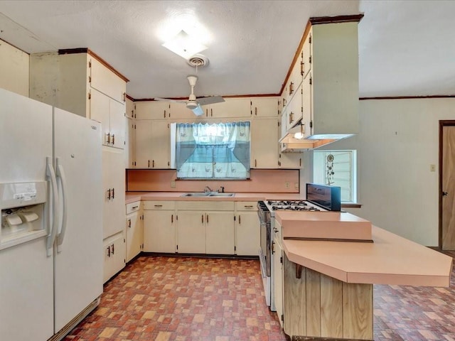 602 Devereaux St, Diboll, TX 75941 - kitchen with white fridge with ice dispenser, range with gas cooktop, ceiling fan, light countertops, and a peninsula