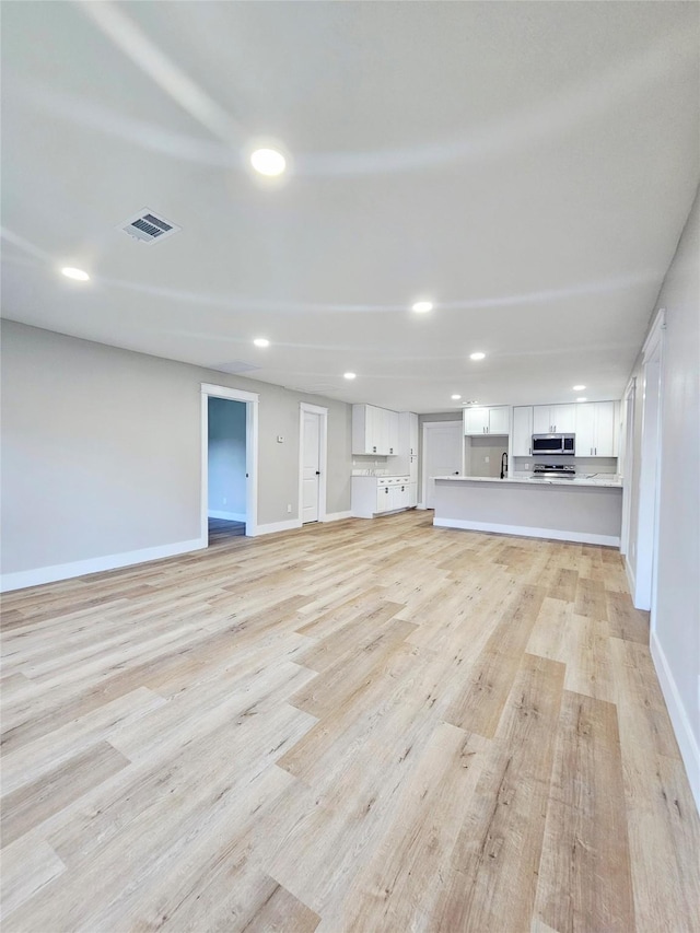 5014 Middleton St, Baytown, TX 77520 - unfurnished living room featuring light wood-style flooring and recessed lighting