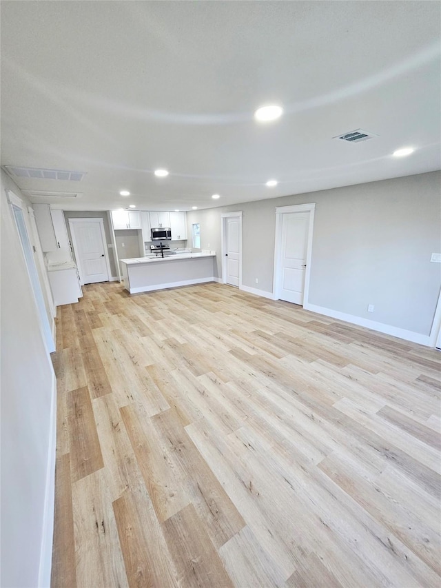 5014 Middleton St, Baytown, TX 77520 - unfurnished living room with light wood-style floors and recessed lighting