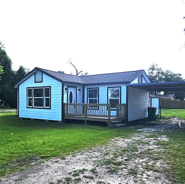 5014 Middleton St, Baytown, TX 77520 - view of front of property featuring dirt driveway, a front lawn, a wooden deck, a shingled roof, and a carport