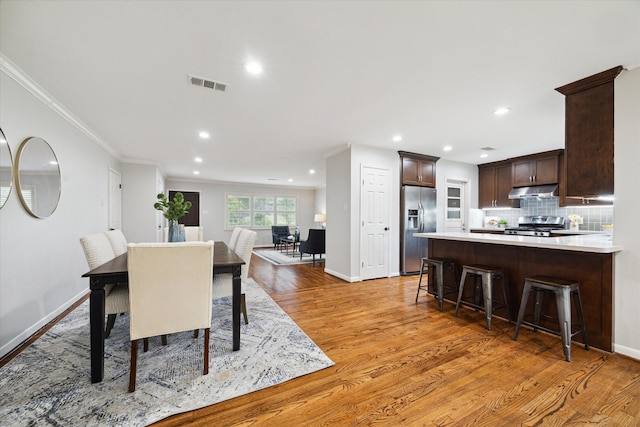 4614 Kinglet St, Houston, TX 77035 - dining room with light wood-style flooring, recessed lighting, and ornamental molding