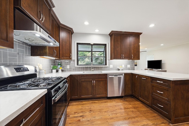 4614 Kinglet St, Houston, TX 77035 - kitchen featuring appliances with stainless steel finishes, extractor fan, a peninsula, light countertops, and recessed lighting