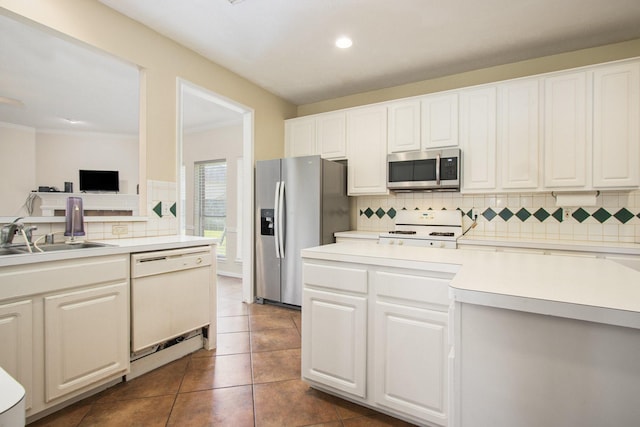2521 Sea Horse Ct, Seabrook, TX 77586 - kitchen featuring appliances with stainless steel finishes, tasteful backsplash, light countertops, white cabinets, and ornamental molding
