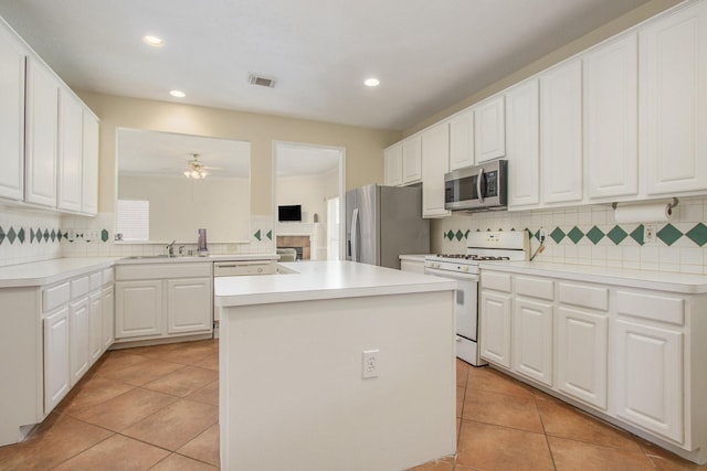 2521 Sea Horse Ct, Seabrook, TX 77586 - kitchen featuring appliances with stainless steel finishes, light tile patterned floors, a center island, decorative backsplash, and recessed lighting
