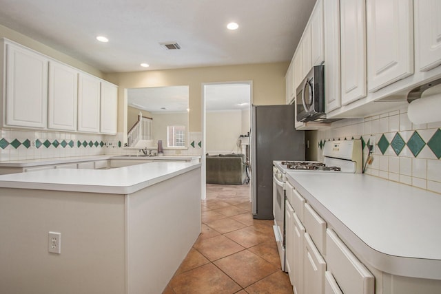 2521 Sea Horse Ct, Seabrook, TX 77586 - kitchen featuring appliances with stainless steel finishes, light countertops, decorative backsplash, white cabinets, and recessed lighting