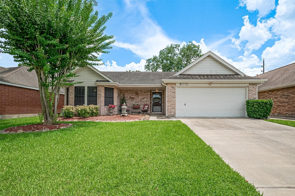 2738 N Larkspur Cir, Pearland, TX 77584 - ranch-style home featuring concrete driveway, a front yard, a garage, and brick siding