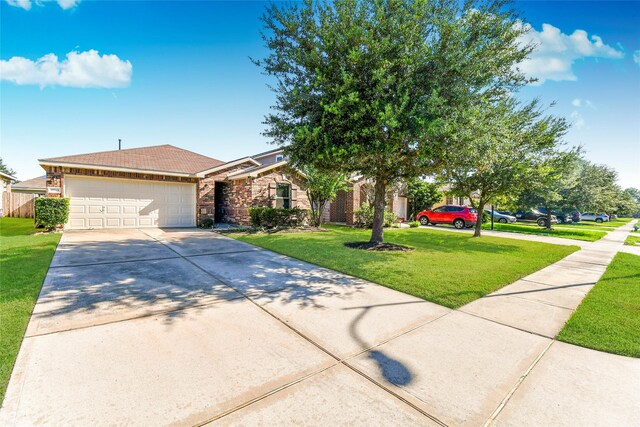 10515 Kentington Oak Dr, Humble, TX 77396 - view of front of house with concrete driveway, a garage, a front lawn, and stone siding