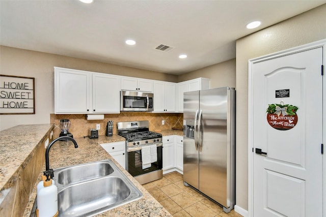 10515 Kentington Oak Dr, Humble, TX 77396 - kitchen featuring stainless steel appliances, tasteful backsplash, white cabinets, light tile patterned floors, and recessed lighting