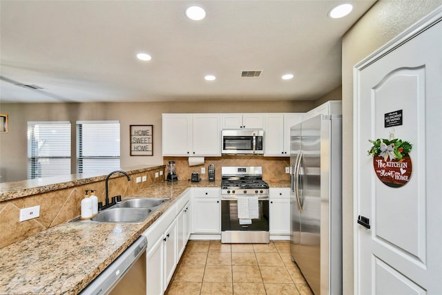 10515 Kentington Oak Dr, Humble, TX 77396 - kitchen with stainless steel appliances, backsplash, white cabinets, light tile patterned floors, and recessed lighting