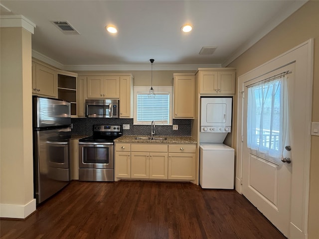 110 E 24th St, Houston, TX 77008 - kitchen featuring appliances with stainless steel finishes, estacked washer and dryer, open shelves, plenty of natural light, and crown molding