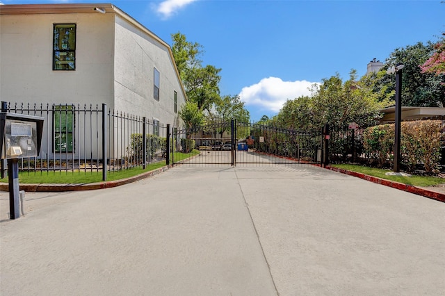 2425 Augusta Dr Unit 30, Houston, TX 77057 - view of concrete road with curbs, a gated entry, and a gate