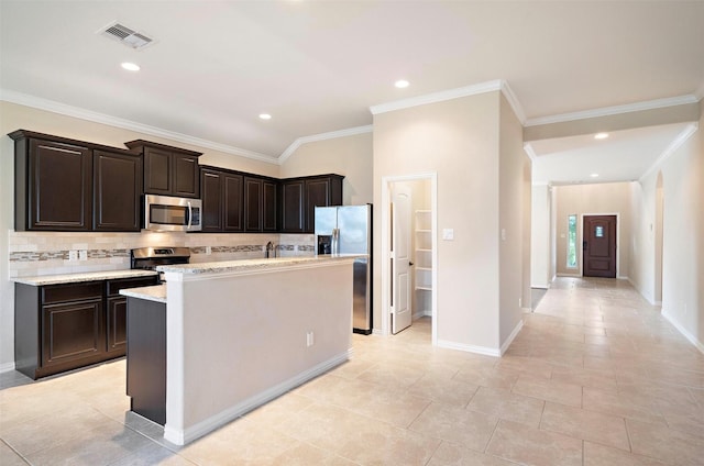 2 Painted Post Pl, Spring, TX 77389 - kitchen with stainless steel appliances, backsplash, a center island with sink, crown molding, and dark brown cabinets