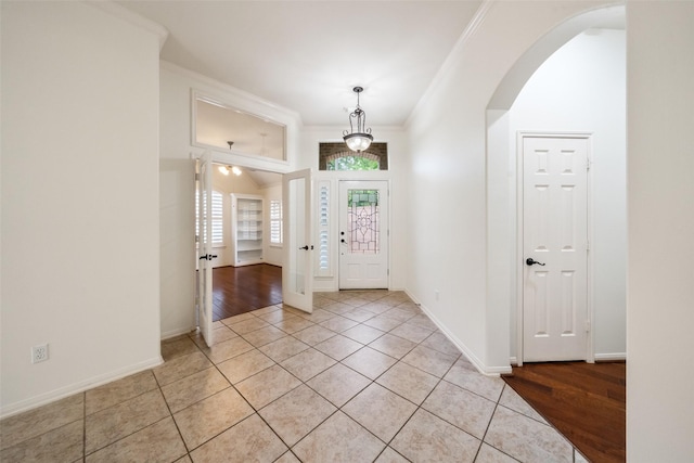 47 Dresden Pl, The Woodlands, TX 77382 - entrance foyer with arched walkways, crown molding, and light tile patterned floors