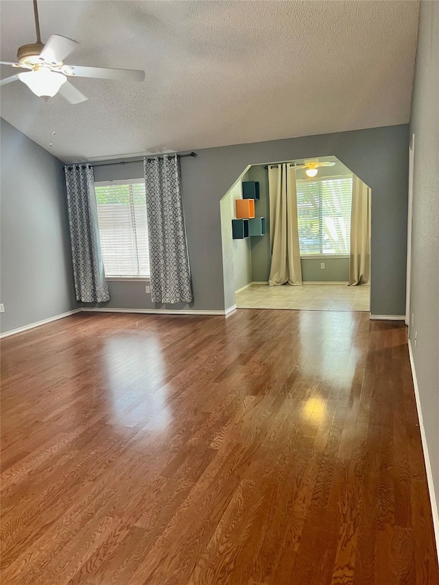 667 E Country Grove Cir, Pearland, TX 77584 - unfurnished living room featuring a ceiling fan, plenty of natural light, a textured ceiling, and wood finished floors