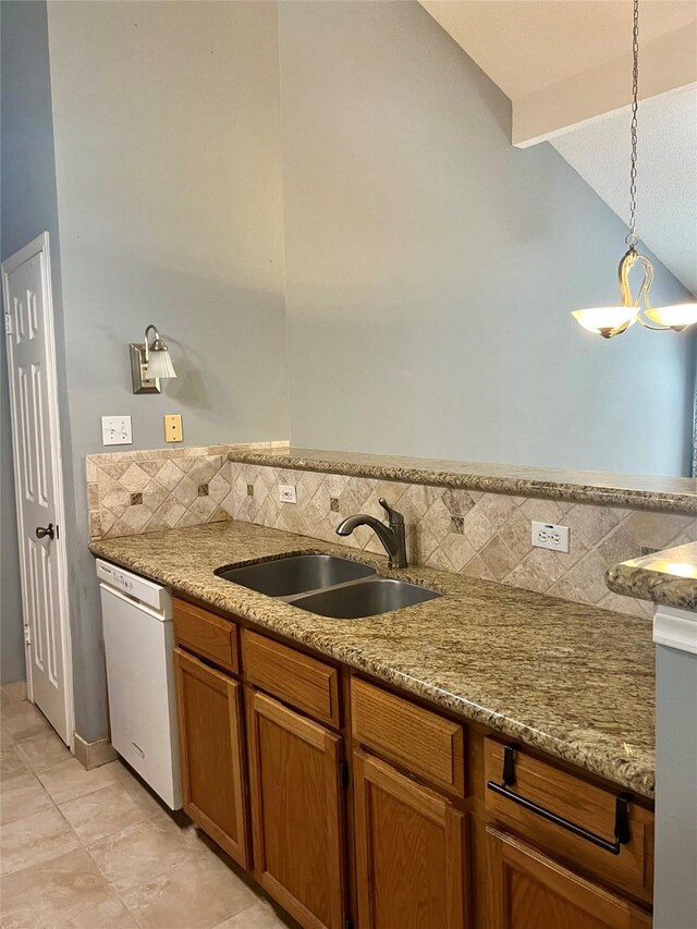 667 E Country Grove Cir, Pearland, TX 77584 - kitchen with white dishwasher, vaulted ceiling, brown cabinetry, backsplash, and hanging light fixtures