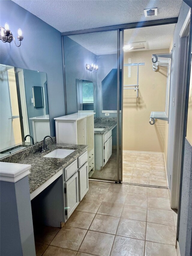 667 E Country Grove Cir, Pearland, TX 77584 - full bathroom featuring a textured ceiling, vanity, a chandelier, a spacious closet, and tile patterned flooring
