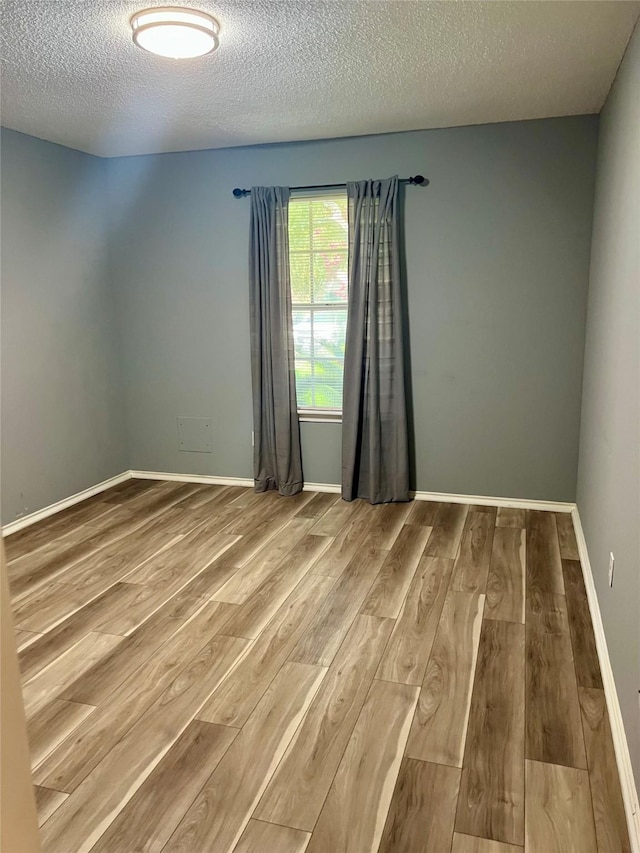 667 E Country Grove Cir, Pearland, TX 77584 - spare room with wood finished floors and a textured ceiling