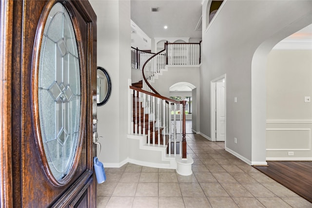 17518 Cypress Laurel St, Houston, TX 77095 - entrance foyer with arched walkways, light tile patterned flooring, stairs, and a towering ceiling