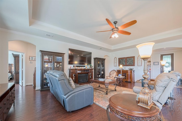 3903 Grand Fir Ct, Richmond, TX 77469 - living area featuring arched walkways, a raised ceiling, a fireplace, a ceiling fan, and ornamental molding